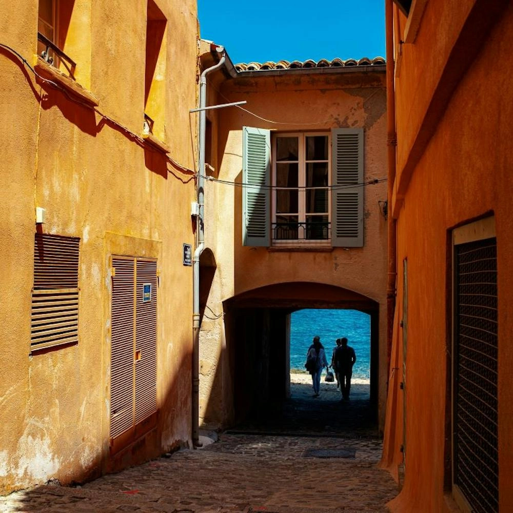Deux personnes marchant sous un arc vers la mer